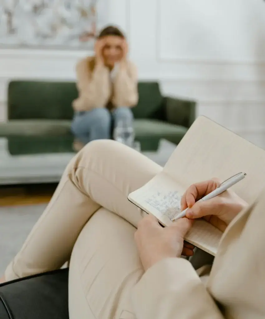 a person sitting in a chair writing in a notebook